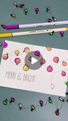 a christmas card and pencil laying on top of a table next to some ornaments with the words merry & bright written in it