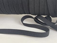 a roll of black satin ribbon on a white background