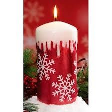 a red and white candle with snowflakes on it