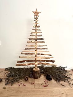 a christmas tree made out of wood sticks and branches with a star on the top