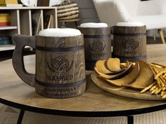 two wooden mugs and some fries on a coffee table with chairs in the background