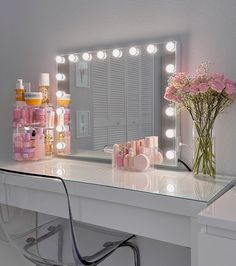 a vanity with lights and flowers on it