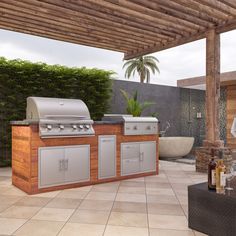 an outdoor kitchen with grill, sink and seating area