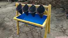 three buckets sitting on top of a wooden stand