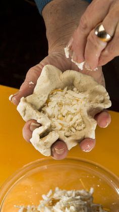 a person holding something in their hand with white powder on it and yellow table behind them