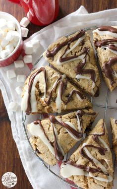 cookies with chocolate drizzle and marshmallows are on a wire rack