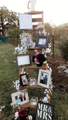 a wooden ladder with pictures and flowers on it in the grass next to a sign that says mr and mrs