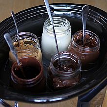 four jars filled with different kinds of desserts