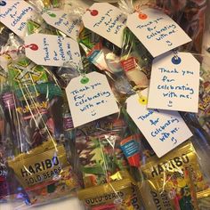 some candy wrapped in plastic bags with writing on them and small tags attached to them