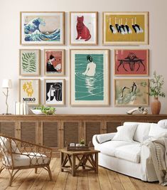 a living room filled with lots of art on the wall above a white couch and wooden coffee table