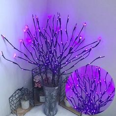 two vases filled with purple lights on top of a white tablecloth covered floor