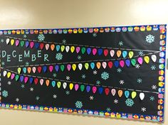 a bulletin board decorated with christmas lights and the words december written in chalk on it