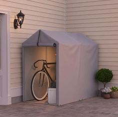 a bicycle is parked in the back door of a house with a cover over it