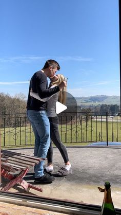 a man and woman standing on top of a roof