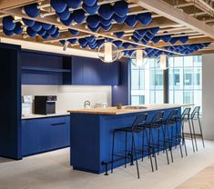 an open kitchen with blue cabinets and stools