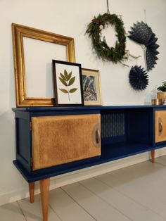 a blue entertainment center with two framed pictures on it