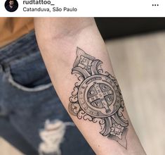 a black and white tattoo on the arm of a person with a cross in it