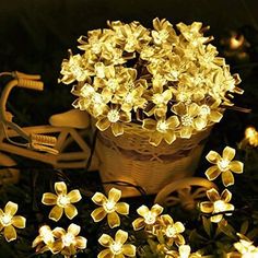 a basket full of flowers sitting on the ground next to a bike and some lights