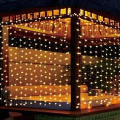 a gazebo covered in christmas lights next to a pool