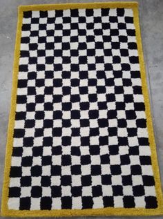 a black and white rug with yellow border