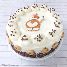 a cake with white frosting and chocolate chips around it, topped with an image of a dog