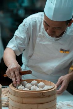 a chef is preparing food in a bamboo steamer basket with chopsticks on the side