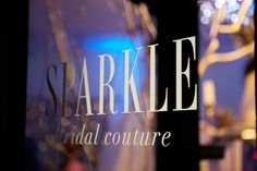 the front window of sparkle bridal couture with lights in the back ground