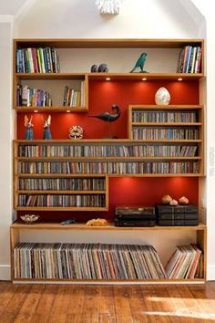 a bookshelf filled with lots of different types of records and cds on top of it