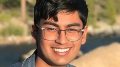 a man with glasses smiling for the camera