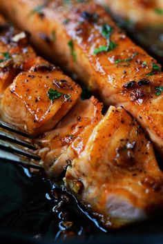 grilled salmon on a black plate with a fork