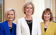 three women standing next to each other smiling