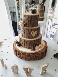 a three tiered wedding cake on top of a table next to the word love