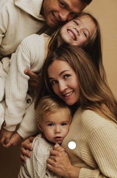 three adults and two children are posing for a family photo with their arms around each other