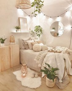 a bedroom decorated in white with plants and lights