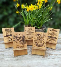 four wooden coasters sitting on top of a table next to yellow flowers and daffodils