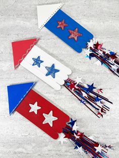 three red, white and blue paper stars on top of each other in the shape of arrows