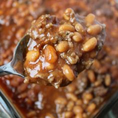 a spoon full of beans and sauce in a bowl