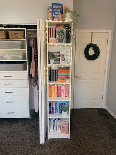 a book shelf filled with books next to a closet