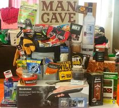 a pile of items sitting on top of a table next to a sign that says man cave