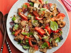 a white plate topped with meat and veggies on top of a red table