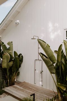 a white house with plants and a wooden deck