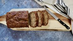 a loaf of bread sitting on top of a wooden cutting board next to a knife