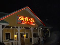 the outside of a steak house at night