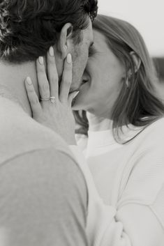 a man and woman kissing each other in black and white