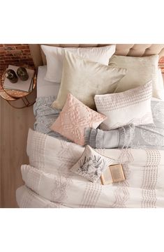 a bed with many pillows and blankets on it