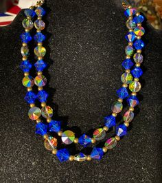 "Beautiful vintage necklace has 2 strands of blue and Aurora Borealis crystal beads. It measures 16\". It is in very good condition." Blue Faceted Round Bead Crystal Necklace, Blue Faceted Crystal Necklace With Round Beads, Blue Double Strand Necklace With Faceted Beads, Vintage Blue Double Strand Jewelry, Blue Double Strand Necklaces For Party, Blue Double Strand Necklace For Party, Vintage Blue Double Strand Necklaces, Blue Crystal Necklaces With Colorful Beads, Blue Crystal Necklace With Colorful Beads