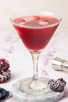 a raspberry martini is garnished with fresh berries