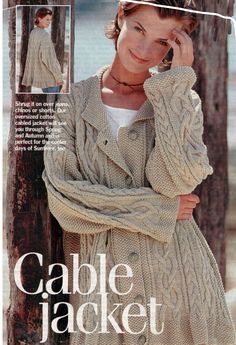 a woman is wearing a cabled jacket and talking on the phone while leaning against a pole