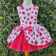 Strawberry birthday party dress, strawberry birthday outfit, berry dress, strawberry boutique dress, berry pageant dress The dress is made in the fabric pictured.  The top skirt has adjustable ties. They can be loosened or scrunched up to your liking. The back of the dress is an open-back style. It ties at the back with wide fabric straps. Handmade in the USA The dress is made by me in my studio in Texas. YOU SELECT TO ORDER THE DRESS ONLY OR DRESS & TUTU. A tutu has been placed underneath the dress in the photos to better display the fabric. In the order options  You are given the choice to order dress only or dress & tutu. If you order the tutu option, a tutu will be added to your order, for wear underneath the dress. Why isn't a tutu automatically included?  I like to give the option to Cute Strawberry Print Dresses For Garden Party, Sweet Red Dress For Birthday, Red Strawberry Print Party Dress, Whimsical Fitted Dress For Tea Party, Pink Strawberry Print Dress For Party, Strawberry Boutique, Strawberry Birthday Party, Berry Birthday, Strawberry Costume