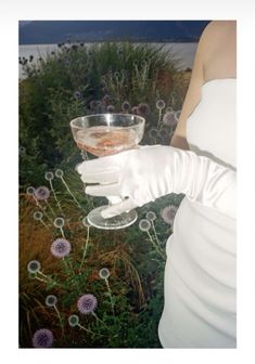 a woman in white gloves holding a glass bowl